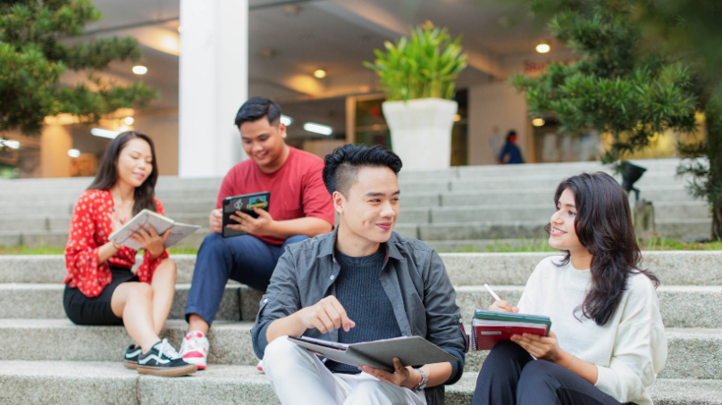 2 pairs of students sitting on amptheatre stairs in taylors uni